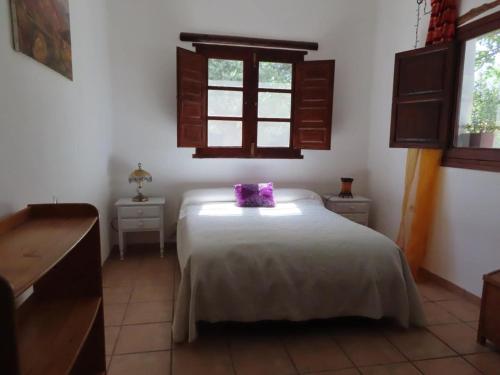 オルヒバにあるBeautiful private outdoor patioのベッドルーム1室(紫色の枕が付いたベッド1台付)