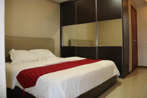 a bedroom with a large bed and a large closet at Thamrin Residence City Home in Jakarta