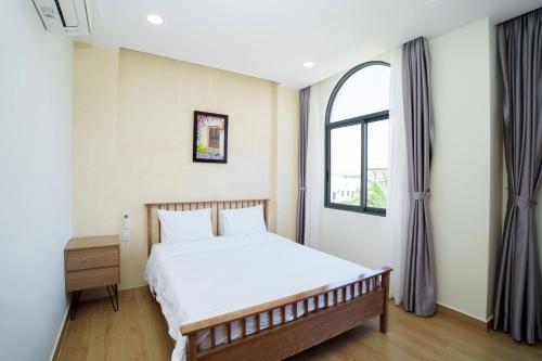 a bedroom with a bed and a window at Happy Stay Resort Wonderland Ho Tram in Xuyên Mộc