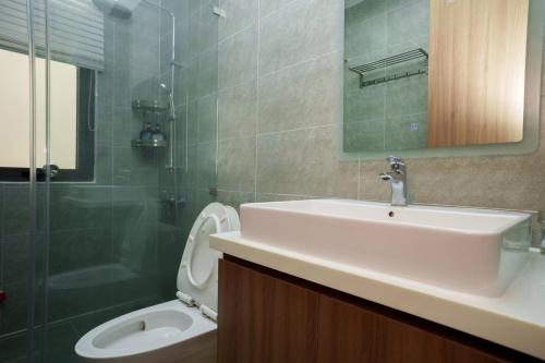 a bathroom with a sink and a toilet and a shower at Happy Stay Resort Wonderland Ho Tram in Xuyên Mộc
