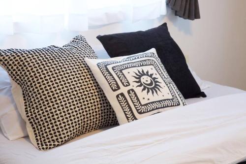 a bed with black and white pillows on it at ラリッサ ヴィラ ウランバル in Azama