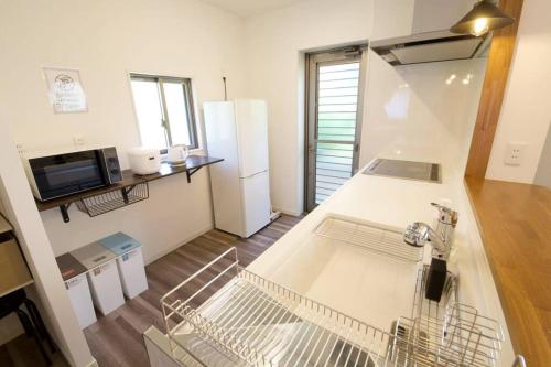 a kitchen with a dishwasher and a refrigerator at ラリッサ ヴィラ ウランバル in Azama