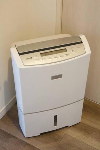 a white machine is sitting on the floor at ラリッサ ヴィラ ウランバル in Azama