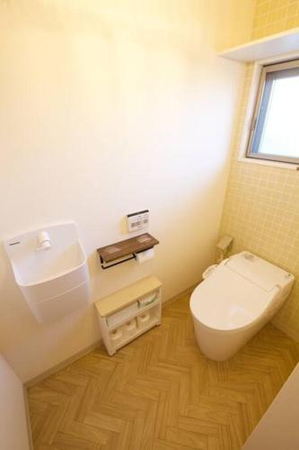 a small bathroom with a toilet and a window at ラリッサ ヴィラ ウランバル in Azama
