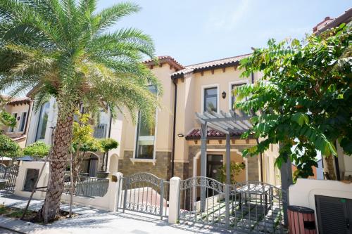 a house with a gate and two palm trees at Happy Stay Resort Wonderland Ho Tram in Xuyên Mộc