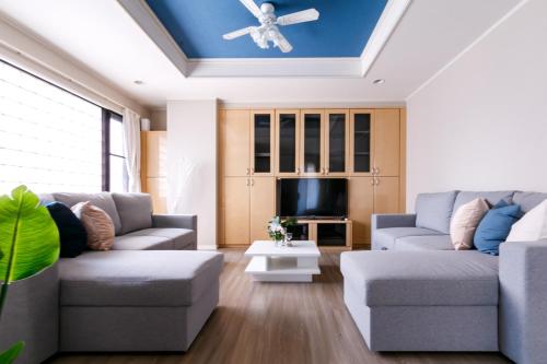 a living room with two couches and a tv at ELLE Namba Villa in Osaka