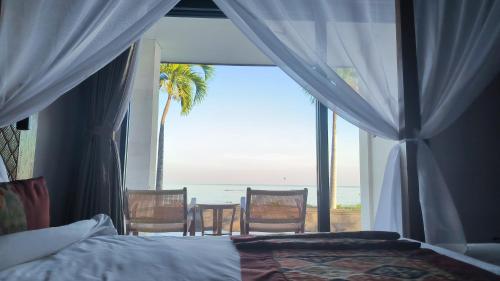 a bedroom with a bed and a view of the ocean at Lovina Haven Boutique Resort in Lovina