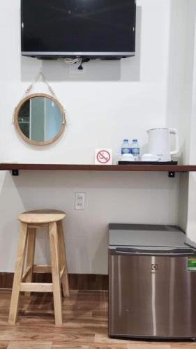 a kitchen with a counter with a stool and a mirror at H Hotel in Quy Nhon
