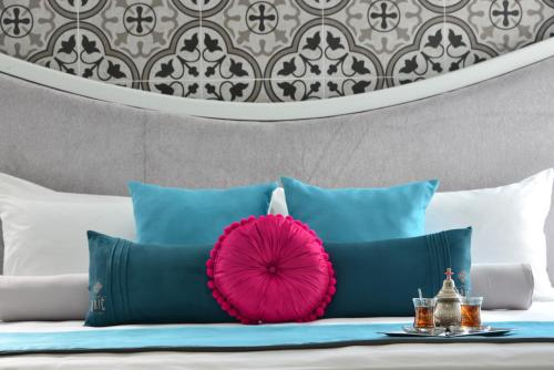 a bunch of pillows on a bed with a pink pillow at Unic Design Hotel & Restaurant- 5th Avenue in Playa del Carmen