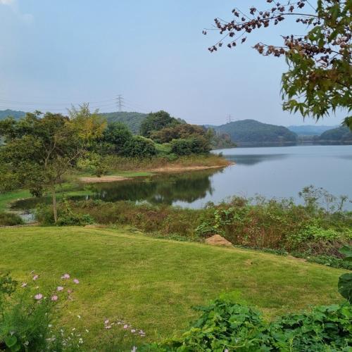 a view of a body of water with trees and grass at Cheongna Stay in Sŏch'on