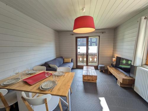 - un salon avec une table en bois et une télévision dans l'établissement Appartement rénové aux Gets, proche centre et pistes, balcon sud - FR-1-623-160, aux Gets