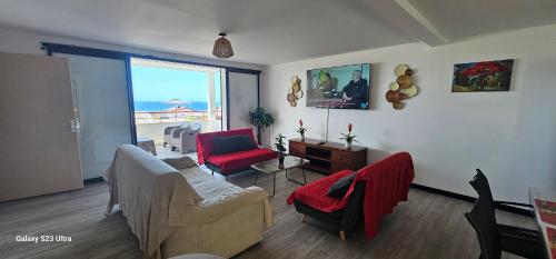 a living room with a couch and chairs and a window at Villa Rosie in Sainte-Rose