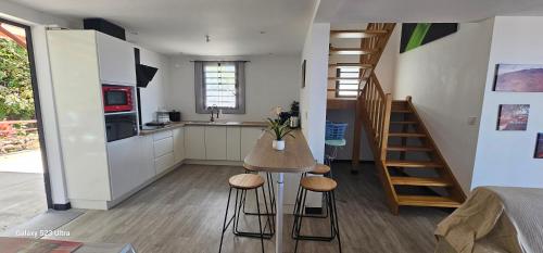 a kitchen with a table and stools in a room at Villa Rosie in Sainte-Rose
