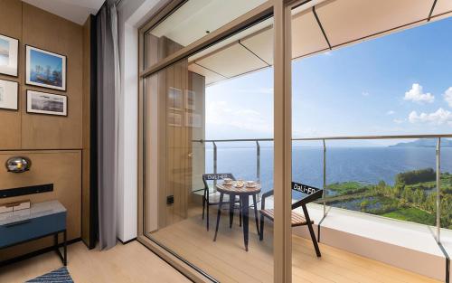 a room with a balcony with a table and chairs at Four Points by Sheraton Dali, Erhai in Dali