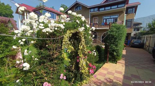 a house with a bunch of flowers in front of it at De brook in Srinagar