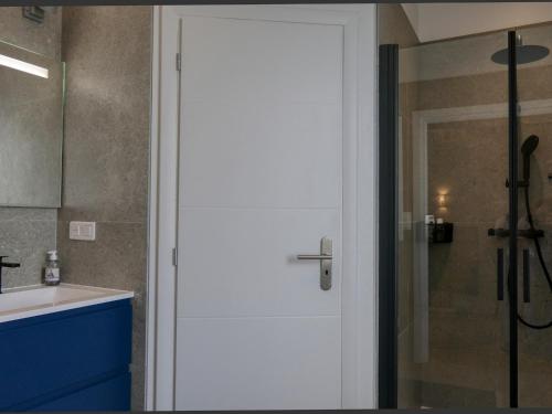 La salle de bains est pourvue d'une douche et d'une porte blanche. dans l'établissement Mas rénové à Ménerbes : piscine privée, clim, wifi, animaux admis, parking - FR-1-708-82, à Ménerbes