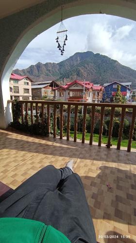 a person laying on a porch with a view of houses at De brook in Srinagar