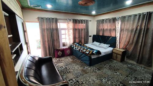 a bedroom with a bed and a couch and a window at De brook in Srinagar