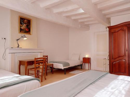 a bedroom with a bed and a desk and a chair at Gîte paisible dans la nature près de Chartres - FR-1-581-142 in Saint-Symphorien