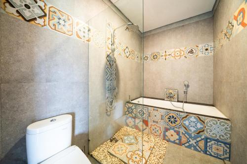 a bathroom with a toilet and a bath tub at Panorama Paddy Paradise in Ubud