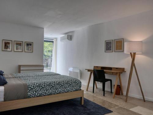 une chambre avec un lit, un bureau et une table dans l'établissement Gîte authentique avec piscine privée, climatisation, Wi-Fi et animaux permis à Ménerbes - FR-1-708-84, à Ménerbes