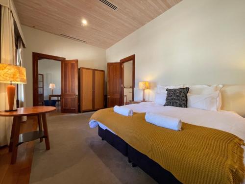 Un dormitorio grande con una cama grande y una mesa. en Yarrabandai Creek Homestead, en Ootha