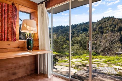 a room with a window with a view of a forest at Enchanted Waterfall Sanctuary in Mill Valley