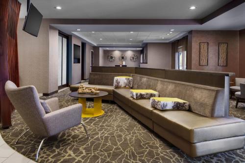 a lobby with a couch and a table and chairs at SpringHill Suites Manchester-Boston Regional Airport in Manchester