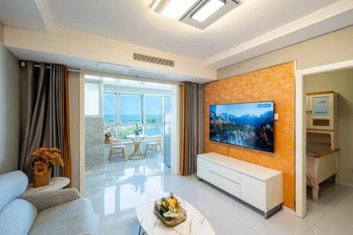 a living room with a tv on a wall at Cloud & Sea Boutique Apartment in Rizhao