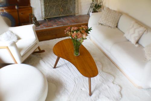 a living room with a vase of flowers on a table at Enchanted Waterfall Sanctuary in Mill Valley