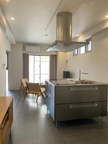 a kitchen with a sink and a stove at 那覇 国際通りまで30秒 1日1組限定のモダン貸切ステイ in Naha