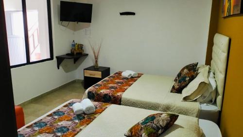 a hotel room with two beds and a television at Hotel San Blass in La Unión
