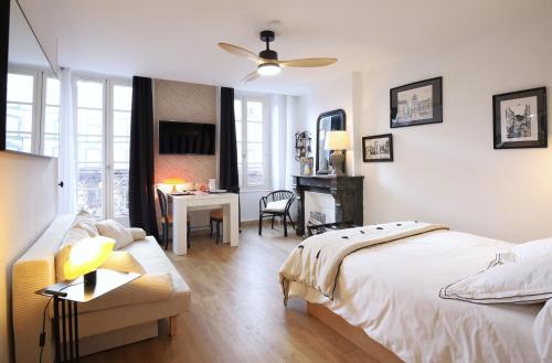 une chambre avec un lit, un bureau et une table dans l'établissement Appartement hyper centre avec balcon, à Clermont-Ferrand