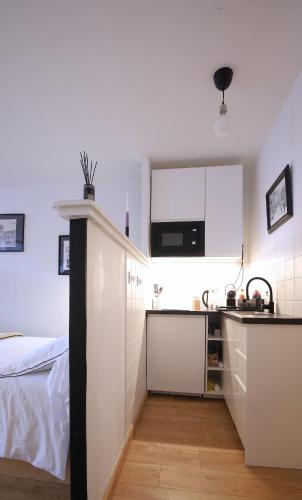 - une petite cuisine blanche avec un évier et un comptoir dans l'établissement Appartement hyper centre avec balcon, à Clermont-Ferrand