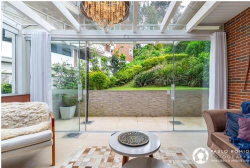 a living room with a couch and a large window at Apartamento Homeland 305 in Gramado