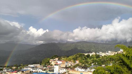 a rainbow in the sky over a city with houses at Hotel San Blass in La Unión