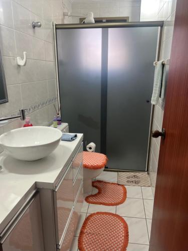 a bathroom with a sink and a toilet and a shower at Apto Pé na Areia Próx Centro Boqueirao PG in Praia Grande
