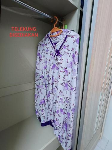 a purple and white shirt hanging on a door at Adempuri homestay in Jitra