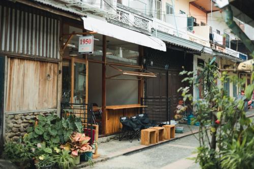 a shop with a sign on the side of a building at 1950 Luangprabang Hostel in Luang Prabang