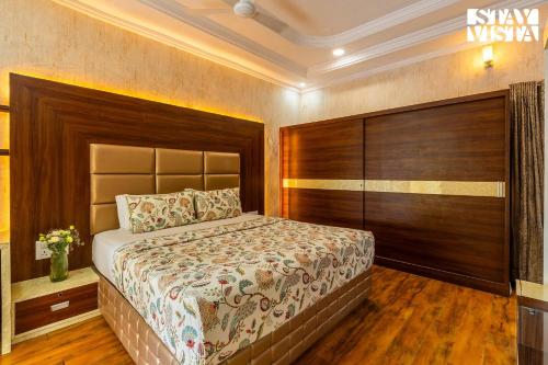a bedroom with a large bed with a wooden headboard at Udaikot by VEO - Part of StayVista in Udaipur
