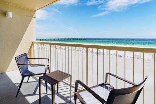 two chairs and a table on a balcony with the beach at Four Points by Sheraton Destin - Fort Walton Beach in Fort Walton Beach