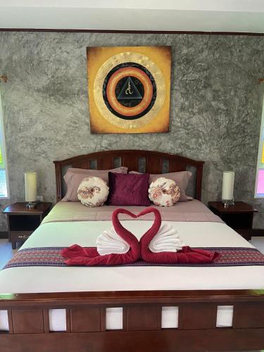 a bedroom with a bed with two heart pillows at Thai Smile Bungalows in Ko Lanta