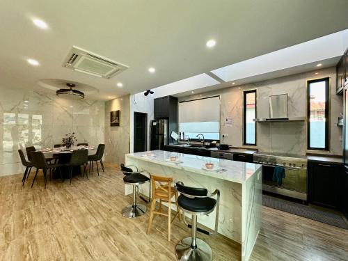 a kitchen and dining room with a table and chairs at Stylish villa alma in Simpang Ampat
