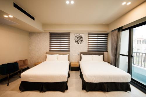 two beds in a room with a window at Chi Fong Ocean City Hotel in Kaohsiung