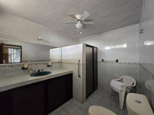 Un baño con lavabo y ventilador de techo. en CasaMadero, en Ciudad Madero
