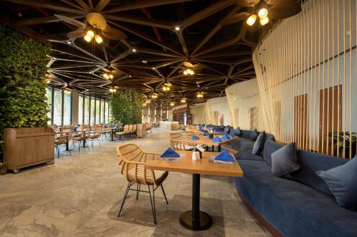 a restaurant with tables and a blue couch at Flamingo Resort Cat Ba in Cat Ba