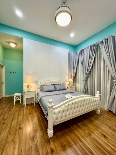 a bedroom with a large white bed and two tables at Stylish villa alma in Simpang Ampat