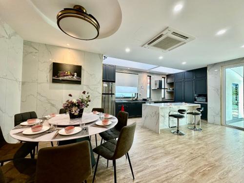 a kitchen and dining room with a table and chairs at Stylish villa alma in Simpang Ampat