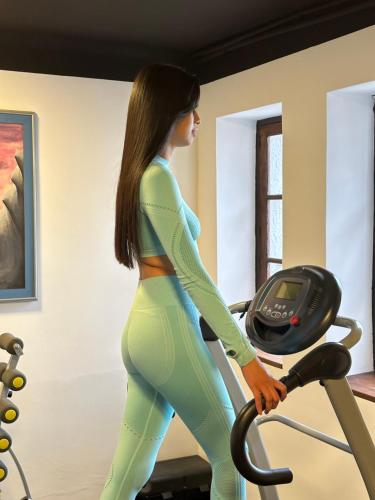 a woman running on a treadmill in a gym at El Museo Hotel Boutique in La Paz