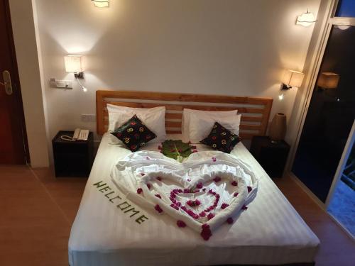 a bed with a heart made out of flowers at Arianna Dhangethi in Dhangethi